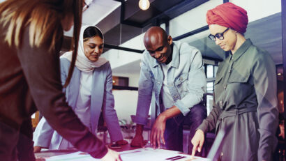 Image of a group of people around a table looking at a document.