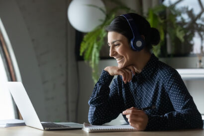 Woman smiling at computer screen