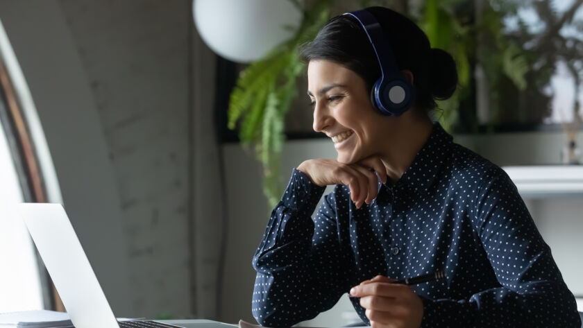 Woman smiling at computer screen