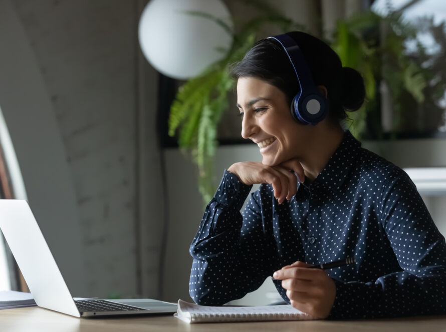 Woman smiling at computer screen