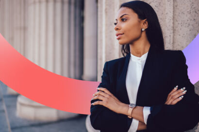 Woman looking away from camera in a suit, crossing her arms.