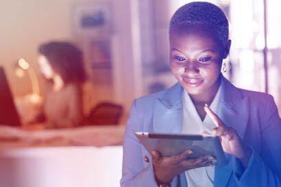 Woman smiling looking at a tablet.