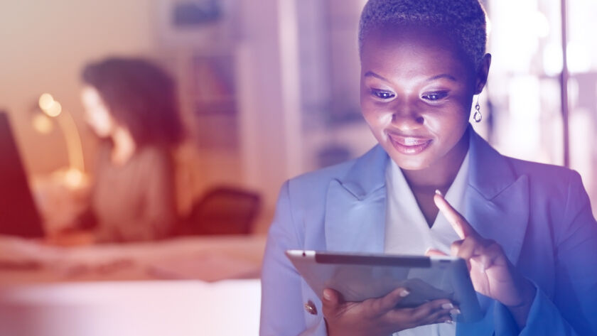 Woman smiling looking at a tablet.