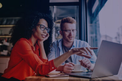 Man and Woman Looking at a Laptop