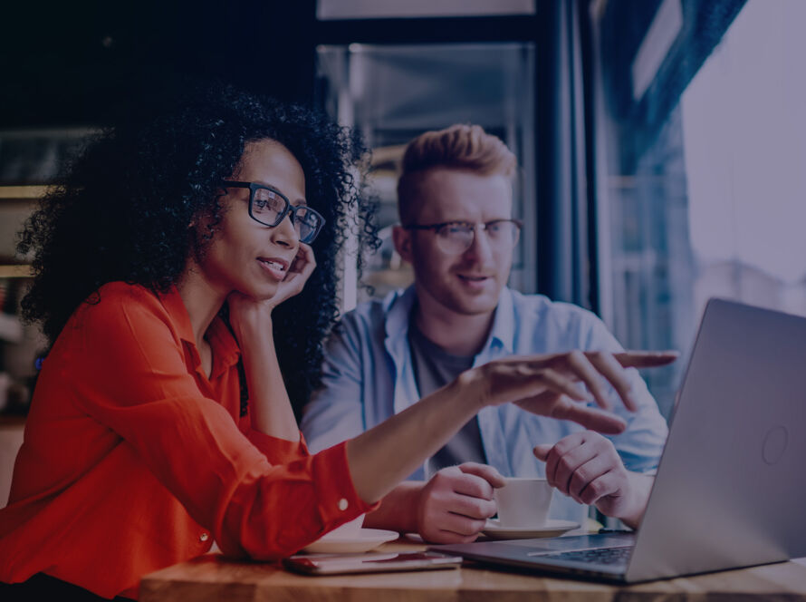 Man and Woman Looking at a Laptop