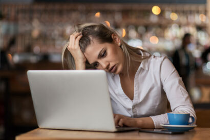 Woman looking frustrated at laptop