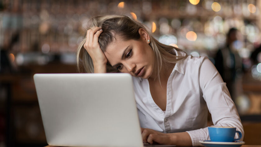 Woman looking frustrated at laptop