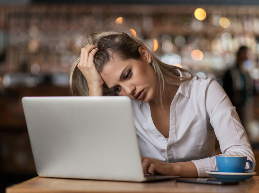 Woman looking frustrated at laptop